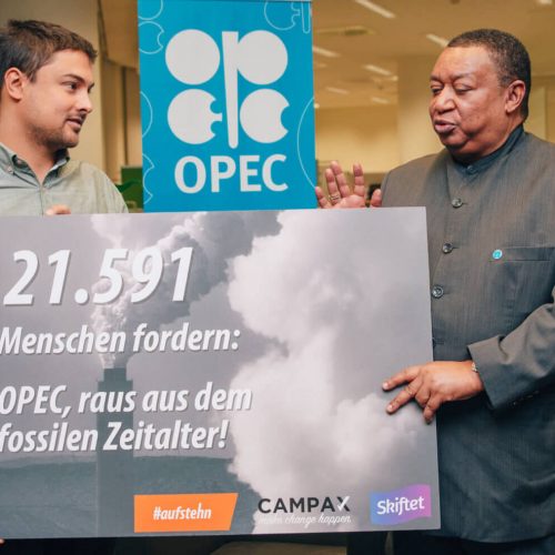 Raoul von #aufstehn und OPEC-Generalsekretär Mohammad Barkindo halten ein Schild, auf dem steht: 21.591 Menschen fordern: OPEC, raus aus dem fossilen Zeitalter!